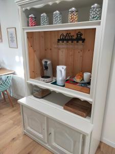 a cupboard with a coffee maker in it at Gite Les Matines in Sebourg