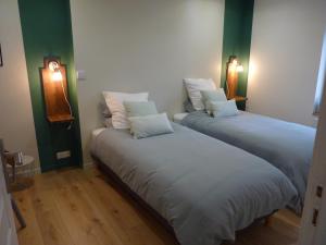 two beds in a room with green and white at Gite Les Matines in Sebourg