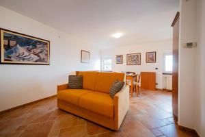 ein Wohnzimmer mit einem orangenen Sofa und einem Tisch in der Unterkunft ApartmentsGarda - Baia Del Garda 5 in Garda