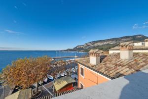 ariale Aussicht auf ein Haus mit Blick auf das Wasser in der Unterkunft ApartmentsGarda - Baia Del Garda 5 in Garda