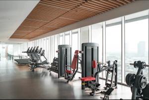 a gym with treadmills and machines in a room with windows at Large Comfortable Bedroom in Alam Sutera Tangerang in Kampungklapa 2
