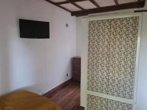 Schlafzimmer mit Schiebetür und TV an der Wand in der Unterkunft Willa Hala in Vinhedo