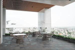 a patio with tables and chairs on a building at Large Comfortable Bedroom in Alam Sutera Tangerang in Kampungklapa 2
