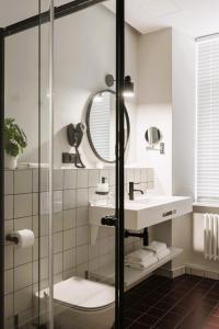 a bathroom with a sink and a mirror at Konventa Sēta Hotel Keystone Collection in Rīga