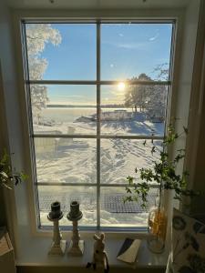 uma janela com vista para um campo coberto de neve em Bastuviken Bed and Breakfast em Uppsala