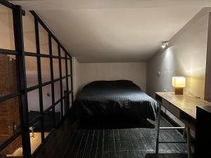a small bedroom with a bed and a desk at Botanic Loft in Tirana