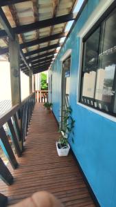 un porche de una casa azul con plantas. en Praia da vieira, en Porto Belo