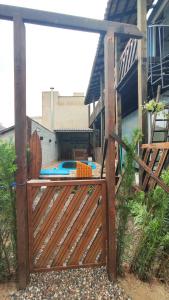 una puerta de madera con una piscina detrás de una casa en Praia da vieira, en Porto Belo