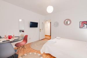 Dormitorio blanco con cama, mesa y silla en Perfect Stay CIPARIU en Cluj-Napoca