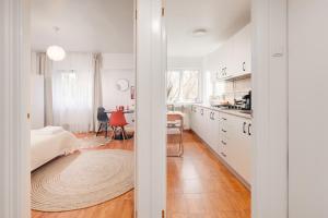 a white kitchen with a bed and a table at Perfect Stay CIPARIU in Cluj-Napoca