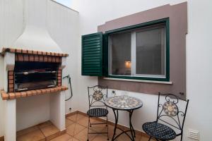 einen Balkon mit einem Tisch und Stühlen sowie einem Fenster in der Unterkunft Estrela do mar in Santa Luzia