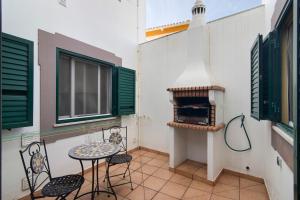 einen kleinen Balkon mit einem Tisch, Stühlen und einem Backofen in der Unterkunft Estrela do mar in Santa Luzia
