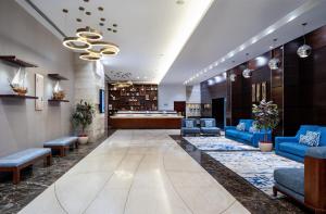 a lobby with blue couches and a waiting room at Four Points by Sheraton Sharjah in Sharjah