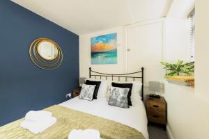 a bedroom with a bed with blue walls and a mirror at Princes Street in the Heart of Bath in Bath