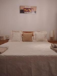 a large bed with white sheets and pillows at Apartamento Delicia in Belmonte