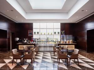 un restaurante con mesas, sillas y una barra en Four Points by Sheraton Sharjah, en Sharjah