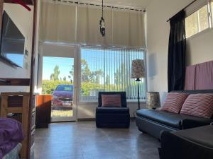 un soggiorno con divano, sedia e finestra di Apartamento Varetto a Sierra de los Padres