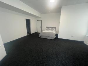 a bedroom with a bed in a white room at Marlborough Court in Hull