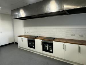 a kitchen with white cabinets and a counter top at Marlborough Court in Hull