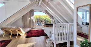 a bedroom with a bed and a large window at The Dragon Tree Guesthouse in Kalk Bay