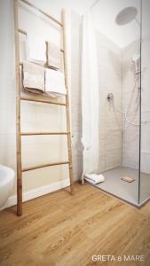 a bathroom with a shower with a ladder and towels at Greta a mare in Montesilvano +27 photos