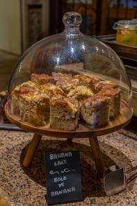 a display of cakes in a glass case on a table at Charming Residence & Guest House Dom Manuel I Adults only in Lagos