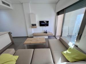 ein Wohnzimmer mit einem Sofa und einem TV in der Unterkunft Modern and Stylish Apartament sea ​​views in Guardamar del Segura