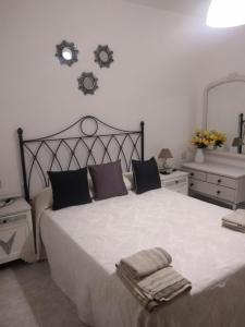 a bedroom with a large white bed with two mirrors at Apartamento Delicia in Belmonte