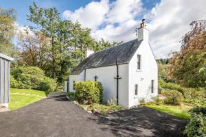 a white cottage with a black roof at Stunning Dalchenna w/hot tub & huge garden in Stirling