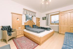 1 dormitorio con 1 cama y 1 silla en Landhaus Stieglschuster, 
