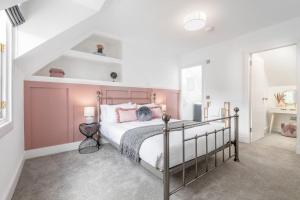 a bedroom with a large bed with pink walls at Stunning Dalchenna w/hot tub & huge garden in Stirling