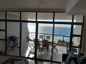 a living room with a table and chairs and the ocean at CoRAL REEF 207 in La Mercy