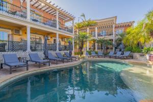 a swimming pool in front of a building with blue chairs at Charming Residence & Guest House Dom Manuel I Adults only in Lagos