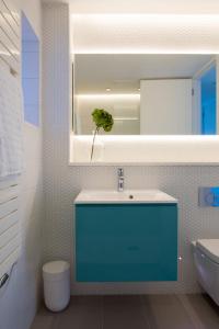 a bathroom with a blue sink and a mirror at Insta-worthy 4br designer house 5 min to the beach in West Wittering