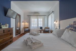 a bedroom with a large white bed with towels on it at Charming Residence & Guest House Dom Manuel I Adults only in Lagos