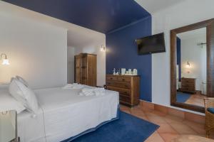 a bedroom with a white bed and a mirror at Charming Residence & Guest House Dom Manuel I Adults only in Lagos