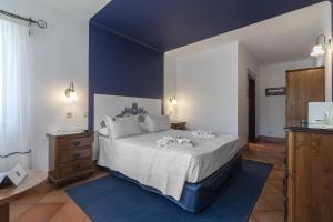 a bedroom with a large bed and a blue wall at Charming Residence & Guest House Dom Manuel I Adults only in Lagos
