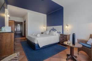 a bedroom with a white bed and a blue wall at Charming Residence & Guest House Dom Manuel I Adults only in Lagos
