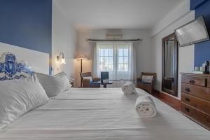 a bedroom with a large white bed with towels on it at Charming Residence & Guest House Dom Manuel I Adults only in Lagos