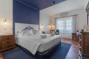 a bedroom with a large bed with a blue wall at Charming Residence & Guest House Dom Manuel I Adults only in Lagos