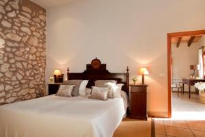 1 dormitorio con cama y pared de piedra en Agroturisme Son Cardaix, en Artà