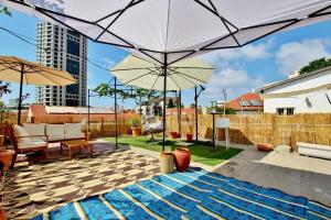 a patio with an umbrella and a pool at The house at shabazi neve tzedek in Tel Aviv
