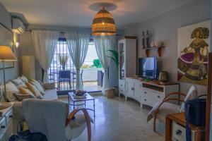 a living room with a couch and a tv at Mijas Costa El Faro 2 Apartamento playa in Mijas