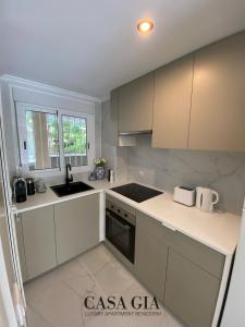 uma cozinha branca com armários brancos e um lavatório em CASA GIA l Luxury apartment Benidorm em Benidorm
