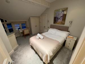 a bedroom with a bed with two towels on it at Fernside house and barns in Pickmere