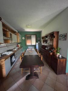a kitchen with a wooden table in a room at Il giardino di Emilia - Intero appartamento in villa con giardino privato e piscina estiva in Pontirolo Nuovo