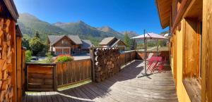 a wooden deck with a chair and an umbrella at Le Longet in Névache