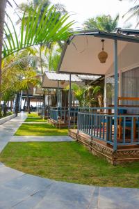 COCO CABANA في بالوليم: منتجع فيه مطعم فيه نخل في الخلف