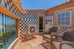 a patio with chairs and a television on a balcony at Charming Residence & Guest House Dom Manuel I Adults only in Lagos