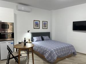 una camera da letto con un letto, un tavolo e una cucina di Malasaña 51, new, center, quite, parking on request a Málaga